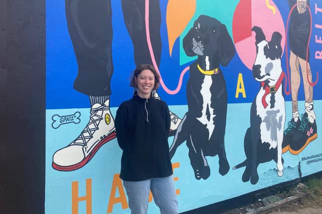 Artist Molly Hankinson, 25,  beside her 'legs and dog' Rudy depicted on the mural at SWG3 in Glasgow. A bone with 'Spatz' was painted as tribute to Molly's other dog who sadly passed away last year (Photo: Hannah Brown).