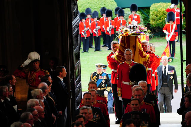King Charles III (left) follows as coffin bearers carry the coffin of Queen Elizabeth II into St George's Chapel in Windsor Castle, Berkshire, for the Committal Service. Picture date: Monday September 19, 2022.