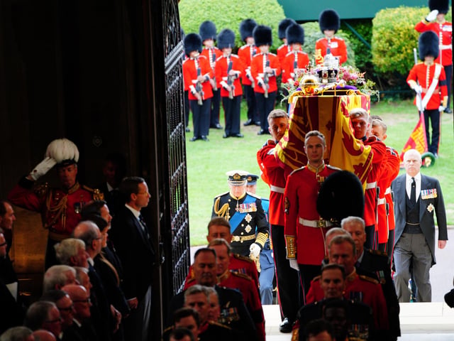 King Charles III (left) follows as coffin bearers carry the coffin of Queen Elizabeth II into St George's Chapel in Windsor Castle, Berkshire, for the Committal Service. Picture date: Monday September 19, 2022.