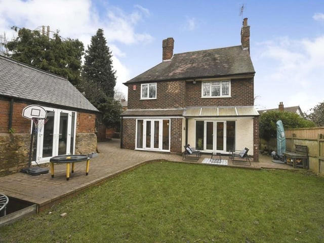 A view of the back of the £325,000 property, showing three sets of French doors - two as part of the main house and the other on the left as part of the detached garage.