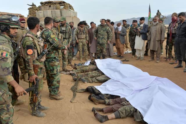 Afgan security forces gather around the bodies of Taliban militants killed during fighting and air airstrikes in the Khogyani district of Nangarhar province in February (Picture: Noorullah Shirzada/AFP via Getty Images)