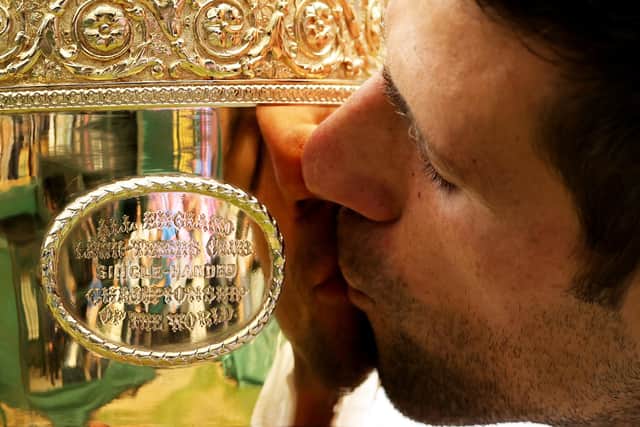 Novak Djokovic of Serbia kisses the trophy after winning his men's singles final match against Matteo Berrettini.