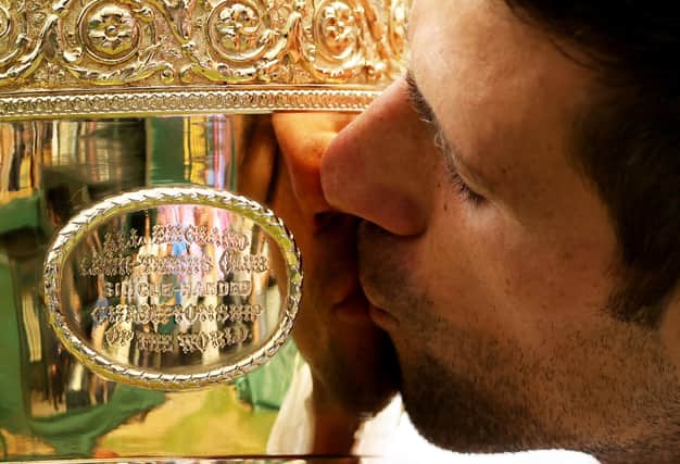 Novak Djokovic of Serbia kisses the trophy after winning his men's singles final match against Matteo Berrettini.