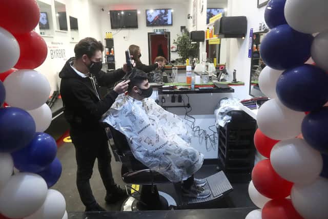 Barber Tony Mann trims Max Mann's hair at Tony Mann's Barber Shop in Giffnock near Glasgow