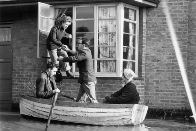 A family in Canvey Island, Essex, is evacuated from their home after the disastrous floods in 1953 (Picture: Topical Press Agency/Getty Images)