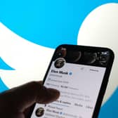 Elon Musk's Twitter account with a Twitter logo in the background  (Photo by Chris DELMAS / AFP) (Photo by CHRIS DELMAS/AFP via Getty Images)