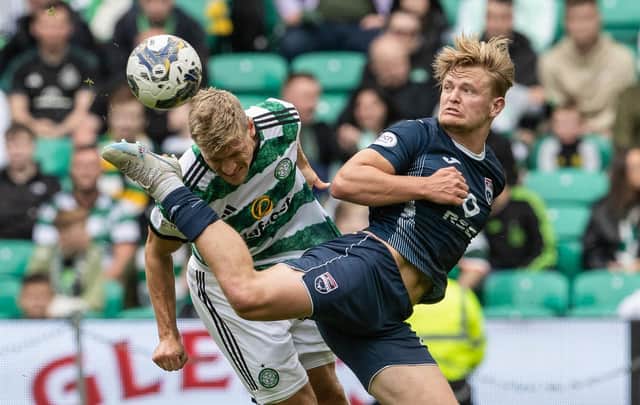 Celtic's Carl Starfelt battles with Ross County's Alex Samuel.