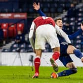 Ryan Christie is bundled to the ground by Austria's Stefan Ilsanker.