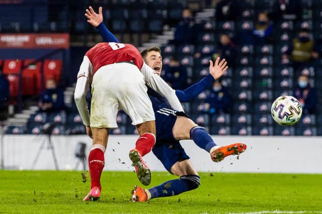 Ryan Christie is bundled to the ground by Austria's Stefan Ilsanker.