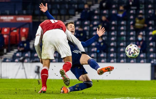 Ryan Christie is bundled to the ground by Austria's Stefan Ilsanker.