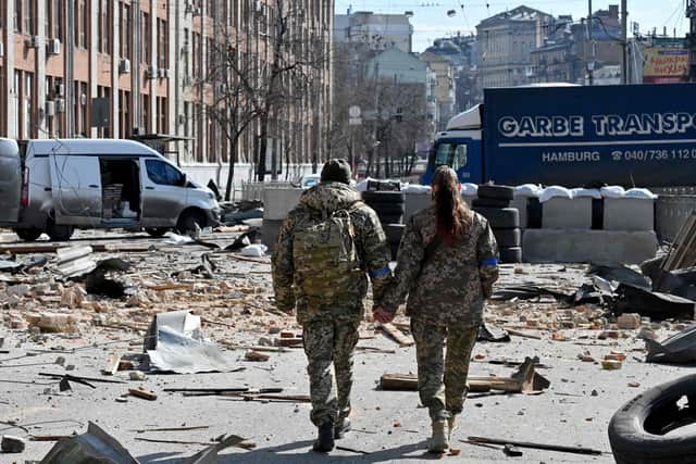 A couple of Ukrainian soldiers walks hand in hand amid Russian invasion of Ukraine in Kyiv. Picture: Sergei Supinsky/AFP via Getty Images