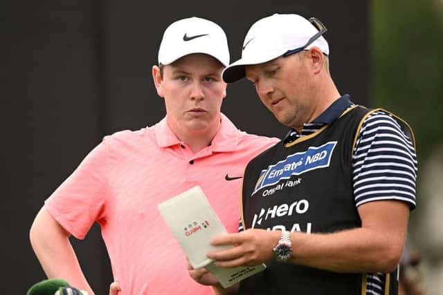Bob MacIntyre and caddie Mikey Thomson check a yardage during the opening round of the Hero Dubai Desert Classic at Emirates Golf Club. Picture: Ross Kinnaird/Getty Images.