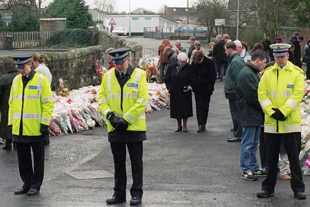 Police officers and local people observe a one-minute silence at Dunblane Primary School following the mass shooting in March 1996 (Picture: Tim Graham/Getty Images)