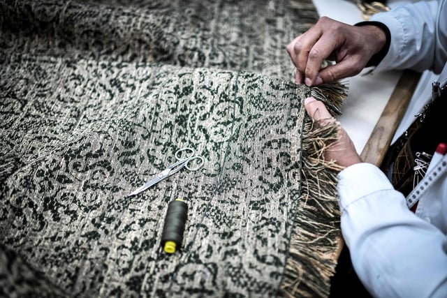An employee works on a couture garment