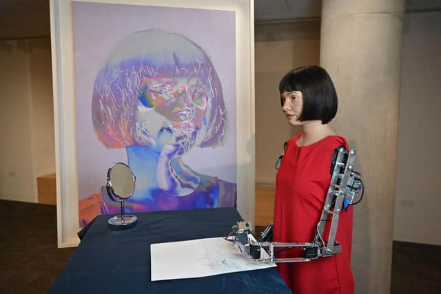 Ultra-realistic AI robot artist Ai-Da, who can draw, paint and is a performance artist, is pictured alongside her self-portrait in 2021