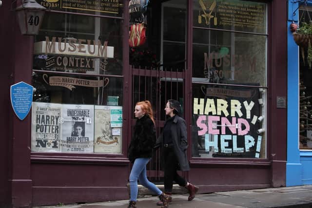 People walk past a sign in a Harry Potter shop in Victoria Street in Edinburgh, the morning after stricter lockdown measures came into force for mainland Scotland. Picture: Andrew Milligan/PA Wire