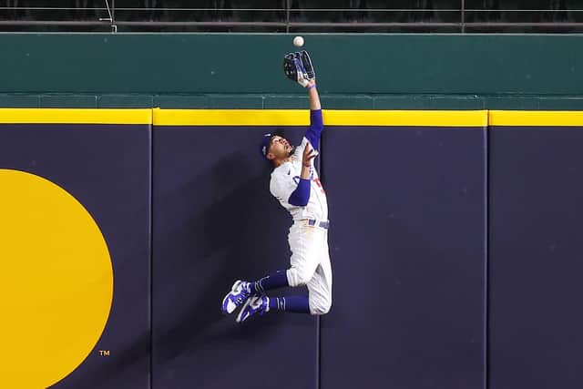 Mookie Betts of the Los Angeles Dodgers catches a fly ball at the wall hit by the Atlanta Braves' Freddie Freeman to prevent a home run in Game Seven of the National League Championship Series.