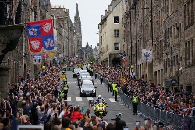 The hearse carrying the coffin of Queen Elizabeth II, draped with the Royal Standard of Scotland, passing along the Royal Mile, Edinburgh, as it continues its journey to the Palace of Holyroodhouse from Balmoral.