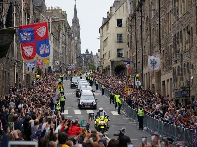 The hearse carrying the coffin of Queen Elizabeth II, draped with the Royal Standard of Scotland, passing along the Royal Mile, Edinburgh, as it continues its journey to the Palace of Holyroodhouse from Balmoral.