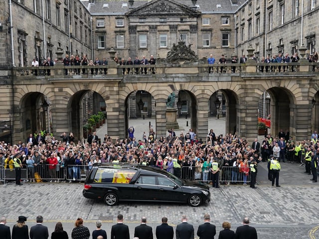 Crowds watch the cortege carrying the coffin of the late Queen Elizabeth II by Mercat Cross in Edinburgh.