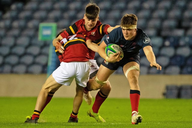 Merchiston's Tom Currie  takes on two Stewart's Melville tacklers
