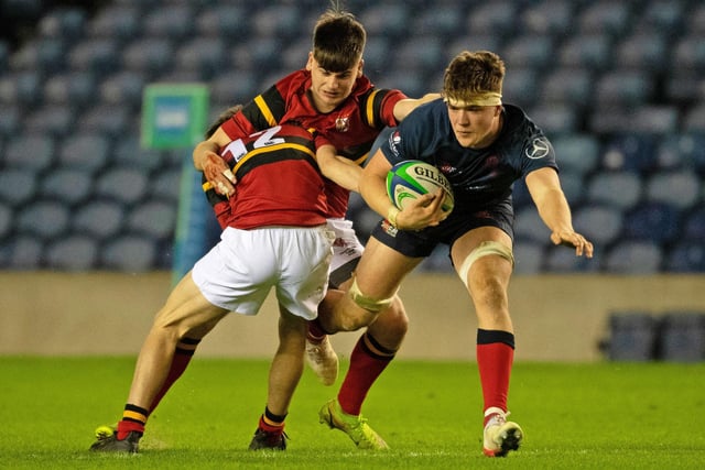 Merchiston's Tom Currie takes on two Stewart's Melville tacklers