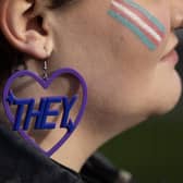 A trans rights activist wears an earring featuring a 'they' pronoun symbol (Picture: Dan Kitwood/Getty Images)