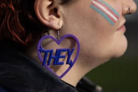 A trans rights activist wears an earring featuring a 'they' pronoun symbol (Picture: Dan Kitwood/Getty Images)