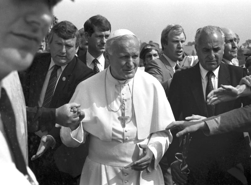 Security is tight but well-wishers manage to touch Pope John Paul II on his arrival at Turnhouse airport.