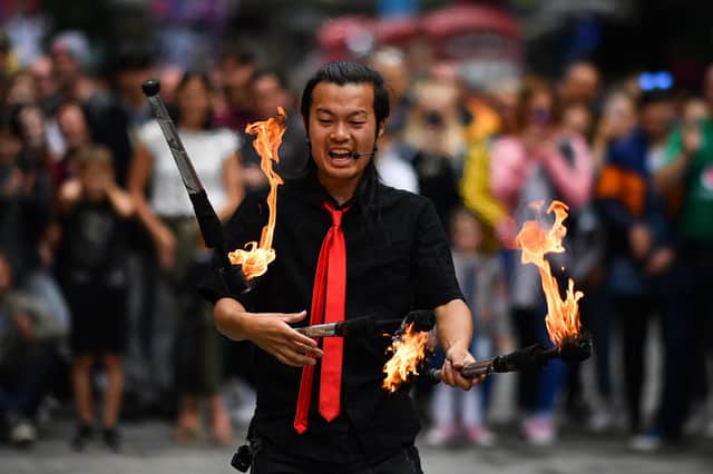 An Edinburgh Festival Fringe entertainer juggles during a performance on the Royal Mile.