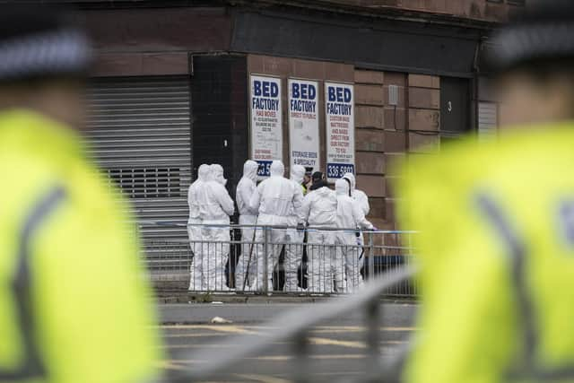 Forensic officers seen combing the scene for clues after the shooting