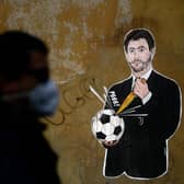 Grafitti entitled 'Il Golpe Fallito', the 'failed coup', by Italian artist Laika, showing Juventus president Andrea Agnelli, an architect of the European Super League plan, puncturing a football, near the headquarters of the Italian Football Federation in Rome (Picture: Filippo Monteforte/AFP via Getty Images)