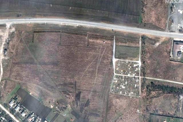 This satellite image provided by Maxar Technologies on Thursday, April 21, 2022 shows an overview of the cemetery in Manhush, 20 kilometers west of Mariupol. The graves are aligned in four sections of linear rows and contain more than 200 graves.