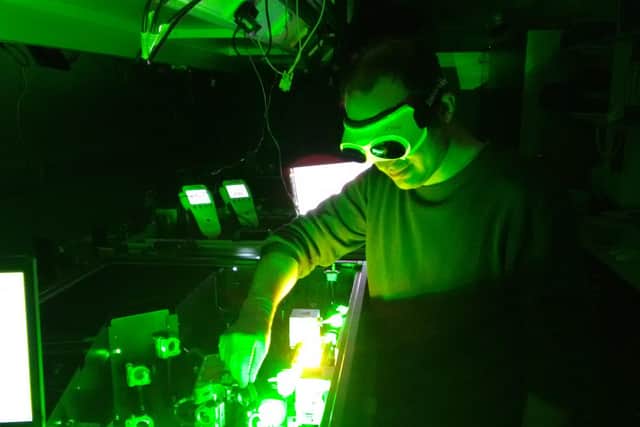 Professor John Travers uses a laser at Heriot-Watt University.