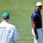 Tiger Woods smiles at caddie Joe LaCava as he warms up ahead of a second practice round prior to the 86th Masters. Gregory Shamus/Getty Images.