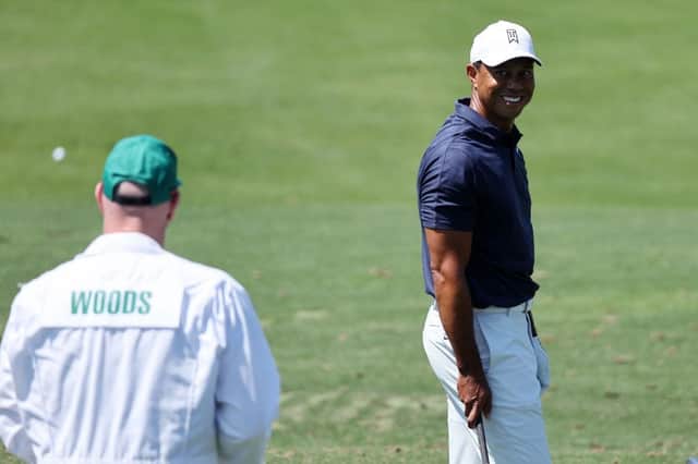 Tiger Woods smiles at caddie Joe LaCava as he warms up ahead of a second practice round prior to the 86th Masters. Gregory Shamus/Getty Images.