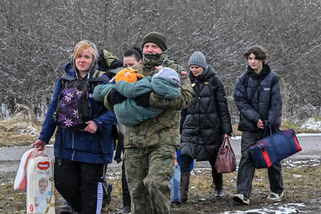 A Polish soldier helps a refugee family after they crossed the border into Poland from Ukraine. Others fleeing Russia's invasion are not as fortunate (Picture: Louisa Gouliamaki/AFP via Getty Images)