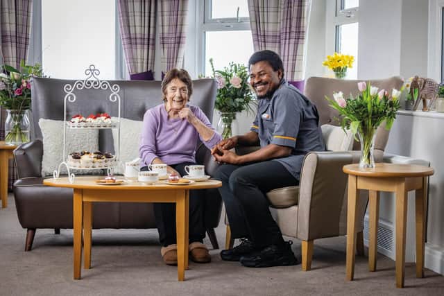 Resident and carer at HC-One care home enjoying coffee and cakes