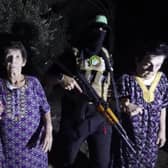 The military wing of Hamas has released a video which it says shows Yocheved Lifshitz (left) and Nurit Cooper with their captors and then being handed over to the International Red Cross.