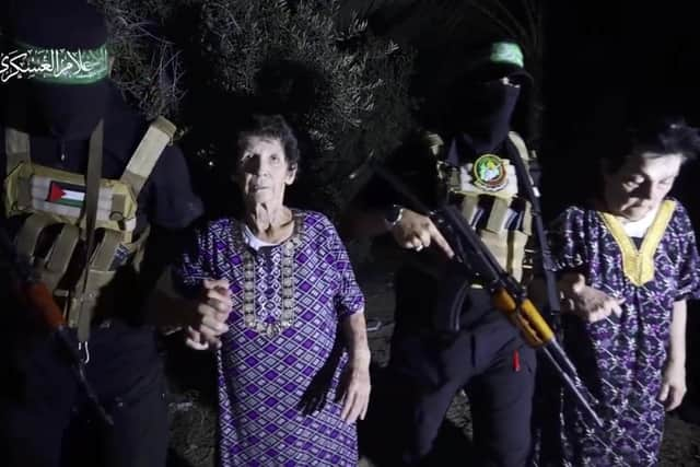 The military wing of Hamas has released a video which it says shows Yocheved Lifshitz (left) and Nurit Cooper with their captors and then being handed over to the International Red Cross.