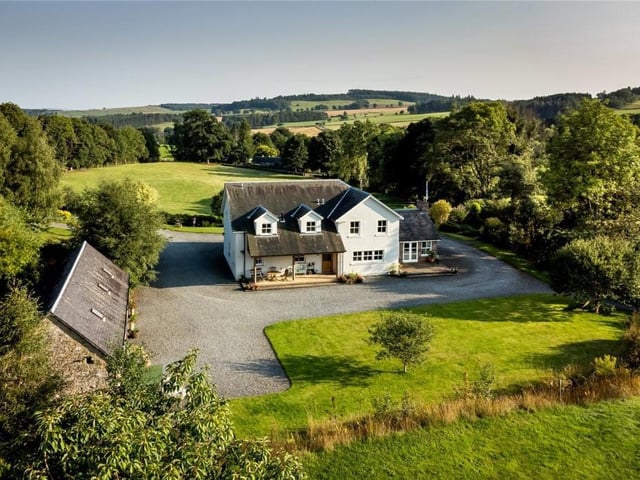 Aerial view of rear of property with outbuilding on left.