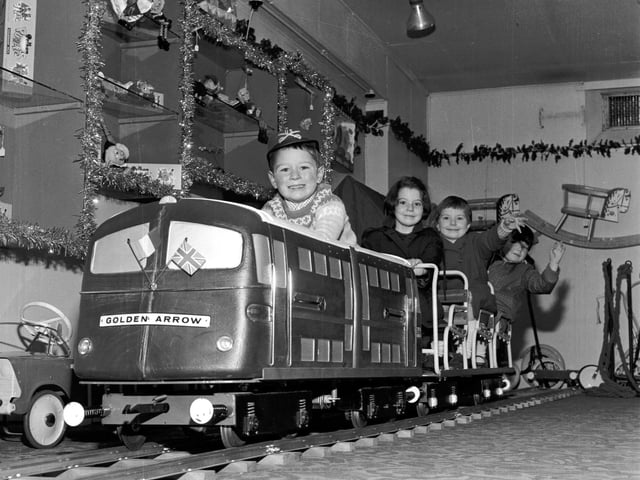 Children here are playing on a model of the Golden Arrow engine in Jenners in November - tinsel and Christmas decorations can be seen on the shelves. Year: 1965