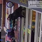 The woman was captured on CCTV footage being lifted into the air while her coat was caught in the shop shutter