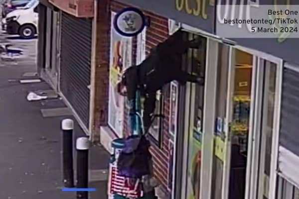 The woman was captured on CCTV footage being lifted into the air while her coat was caught in the shop shutter