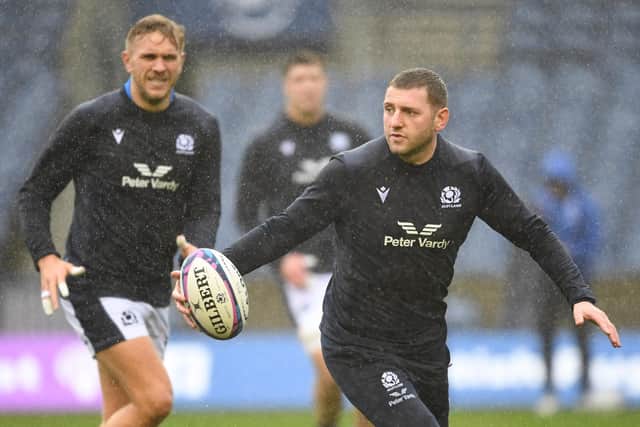 Finn Russell gets a feel of the ball during the Scotland team run at a rainy Murrayfield ahead of the Argentina match, with Chris Harris on the left. (Photo by Ross MacDonald / SNS Group)