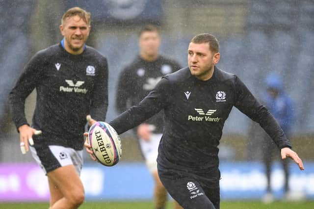 Finn Russell gets a feel of the ball during the Scotland team run at a rainy Murrayfield ahead of the Argentina match, with Chris Harris on the left. (Photo by Ross MacDonald / SNS Group)