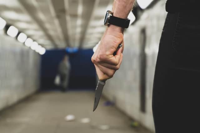 A thief with a knife goes to attack and rob another person in a tunnel. Picture: Getty Images