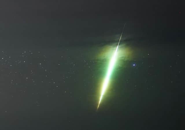 A fisherman watches a meteor during the Draconid meteor shower over Howick rocks in Northumberland.