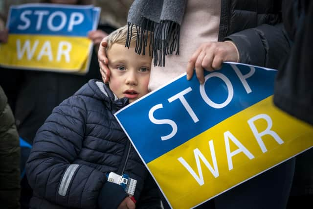 People take part in the Standing In Solidarity With Ukraine vigil on The Mound, Edinburgh, following the Russian invasion of Ukraine. Picture: Jane Barlow/PA Wire