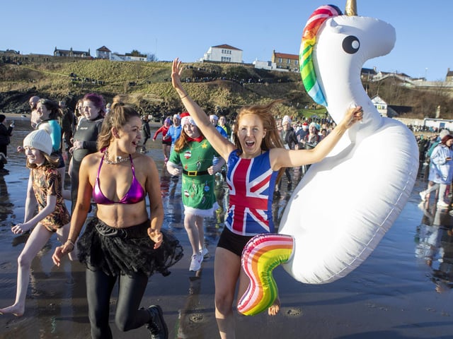 Over one hundred people take part in the Kinghorn Loony Dook New Years Day swim on the Fife coast of the Firth of Forth